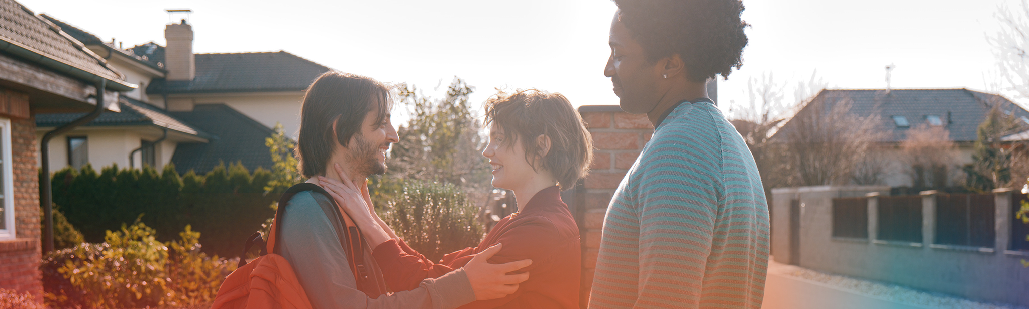 Young man with woman holding his shoulders and a man to the side