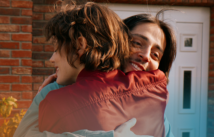 Man smiling while hugging woman