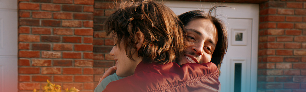 Man smiling while hugging woman