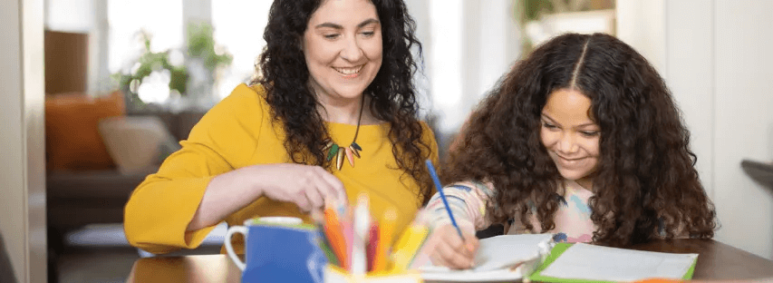 Mother and daughter working on crafts together at a table