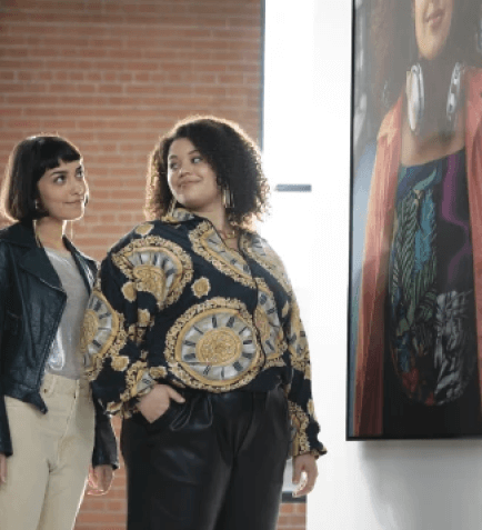 Two women in an art gallery looking at art together