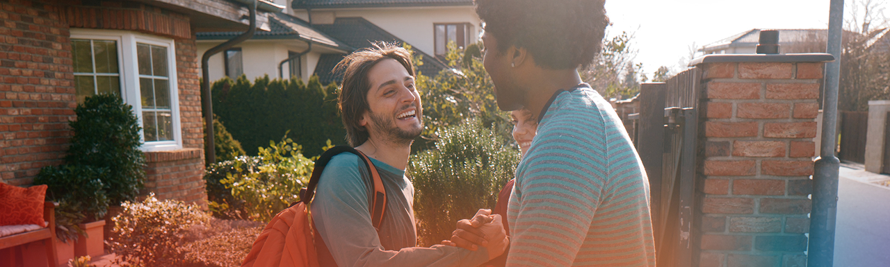 Young man greeting a man and woman with a smile