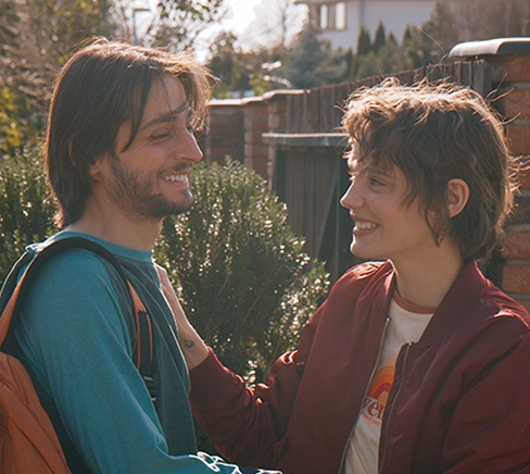 Man smiling greeting woman embracing him and smiling